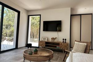 a living room with a flat screen tv on the wall at Villa avec Piscine et Spa in Vinassan
