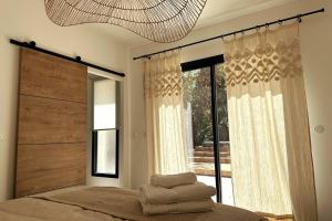 a bedroom with a bed and a large window at Villa avec Piscine et Spa in Vinassan +13 photos
