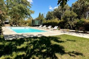 a swimming pool with lounge chairs in a yard at Villa avec Piscine et Spa in Vinassan