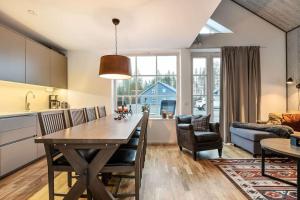 a kitchen and living room with a table and chairs at Mysig fjällstuga i Idre Fjällfoten in Idre