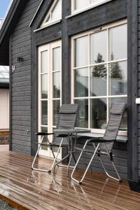dos sillas y una mesa en una terraza frente a una casa en Mysig fjällstuga i Idre Fjällfoten en Idre