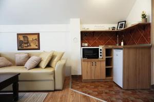 a living room with a white couch and a microwave at Airport Studio Loft - Galleria in Belgrade