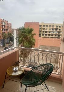 Appartement agréable en plein coeur de Marrakech pour 2 à 4 Personnes في مراكش: شرفة مع كرسيين وطاولة على شرفة