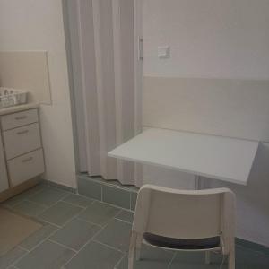 uma cozinha com uma mesa branca e uma cadeira em Mina em Laichingen