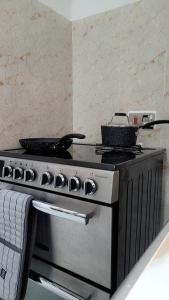 a kitchen stove with two pans on top of it at Mlandege Town house in Ngambo