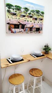 a table with two chairs and a painting on the wall at Mlandege apartment in Ngambo