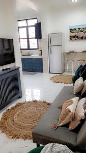 a living room with a couch and a kitchen at Mlandege apartment in Ngambo