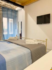 two beds in a room with a flat screen tv at IL RIFUGIO BAROCCO in Modica +17 photos