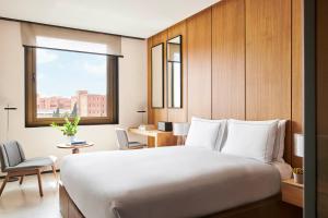 - une chambre avec un grand lit blanc et une fenêtre dans l'établissement Grand Hyatt Barcelona, à Barcelone