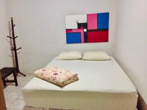 a bed in a room with a painting on the wall at Casa Brisas in Luis Correia