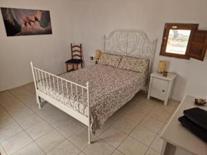 a bedroom with a white bed and a chair at Casa De La Familia - Appartement in Baza