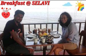 Selavi Resort Bentota في بينتوتا: رجل وامرأة يجلسون على طاولة