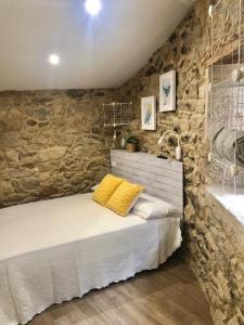 um quarto com uma cama e uma parede de pedra em Casa Arrabal em Oia