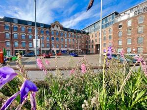a courtyard with purple flowers in front of a building at Spacious 2 Bedroom Apartment with Parking in Nottingham