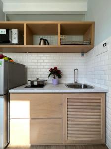 een keuken met een wastafel en een koelkast bij Zen Apartment in Ho Chi Minh-stad