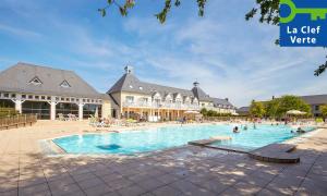 a large swimming pool in front of a building at Résidence Pierre & Vacances Green Beach in Port-en-Bessin-Huppain