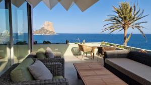 een patio met een tafel en stoelen en de oceaan bij Al Vent by Solhabitat rentals in Calpe