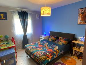 - une chambre avec un lit et un mur bleu dans l'établissement VILLA des CHEMINS, à Cussac-sur-Loire