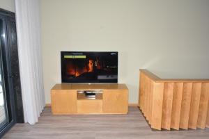 een flatscreen-tv bovenop een houten entertainmentcentrum bij A3J Country House Lagares in Penafiel