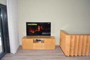 a flat screen tv sitting on top of a wooden entertainment center at A3J Country House Lagares in Penafiel