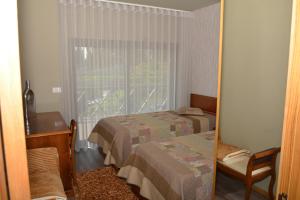 a hotel room with two beds and a window at A3J Country House Lagares in Penafiel