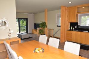 uma cozinha e sala de jantar com mesa e cadeiras em A3J Country House Lagares em Penafiel