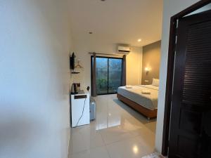 a bedroom with a bed and a window at ซีมอน เกสเฮ้าส์ in Phetchaburi