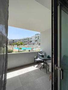 a balcony with a table and a view of a pool at Paradise Palms I Deluxe, incl. Welcome Package in Corralejo