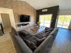 a living room with a large couch and a tv at Boost Your Immo Corse Solenzara Tozza Alta 818 in Le Pont du Travo