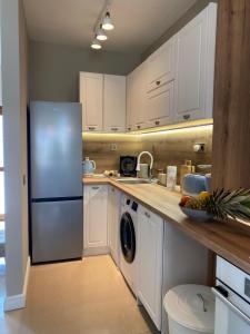 a kitchen with white cabinets and a refrigerator at Villa Lavanda Golf in Balchik