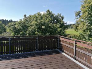 a wooden deck with a fence and trees at Feriendomizil Naturliebe in Dornhan
