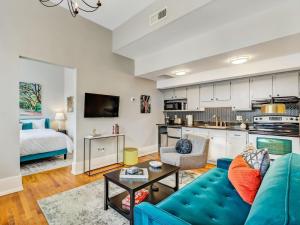 a living room with a blue couch and a kitchen at The Haywood in Savannah