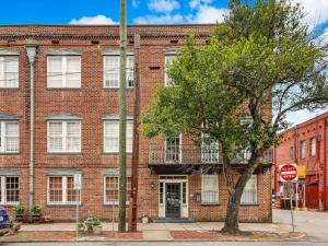 a red brick building with a tree in front of it at The Haywood in Savannah