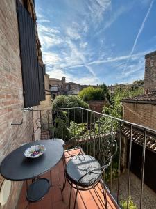 a balcony with a table and chairs on a balcony at Dimora '800 in Ferrara