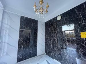 a bathroom with a chandelier and black marble walls at Modern cozy apartment ultracentral in Chişinău +8 photos