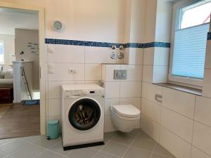 a bathroom with a washing machine and a toilet at Ferienwohnung-Seepferdchen-Finnlandring in Timmendorfer Strand +15 photos