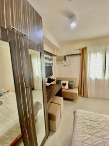 a bedroom with a bed and a living room at Nice location in the persimmon condo in Cebu City