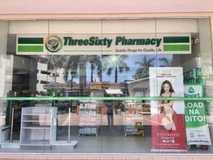 a store front of a pharmacy with a sign in the window at Nice location in the persimmon condo in Cebu City
