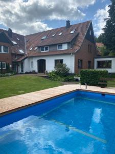 a large swimming pool in front of a house at Ferienhof Kröger in Bielefeld