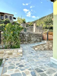 una pasarela de piedra con una pared de piedra y un jardín en Kounia Bella - Palio Mikro Chorio, en Mikrón Khoríon