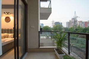 een balkon met een bed en uitzicht op de stad bij Serviced Apartment near Medanta by BedChambers in Gurgaon