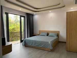 Tuy AnにあるSATURDAY Homestay Tuy Hòa - Phú Yênのベッドルーム(ベッド1台付)、バルコニーが備わります。