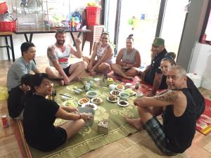 峰牙的住宿－Phong Nha Escape Bungalow，一群坐在地板上吃食物的人