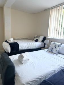 a bedroom with two beds with towels on them at City Stay in Colchester