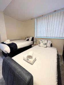 a bedroom with two beds and a window at City Stay in Colchester