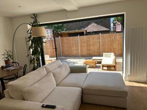 ein Wohnzimmer mit einem Sofa und einer Terrasse in der Unterkunft Luxurious, spacious, sunny & modern apartment in London
