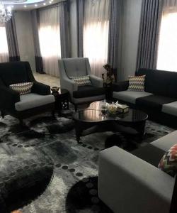 un soggiorno con divani, tavoli e finestre di شقق المومني ad Amman