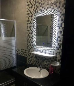 un bagno con lavandino e specchio di شقق المومني ad Amman