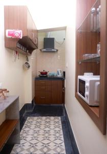 uma pequena cozinha com micro-ondas e piso de cozinha em Olys Apartment Gariahat em Calcutá