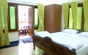 a bedroom with a bed and a large window at Olys Apartment Gariahat in Kolkata